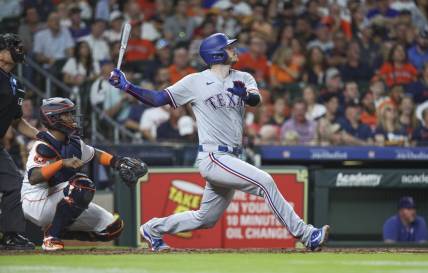 Jul 25, 2023; Houston, Texas, USA; Texas Rangers catcher Jonah Heim (28) hits a single during the fifth inning against the Houston Astros at Minute Maid Park. Mandatory Credit: Troy Taormina-USA TODAY Sports