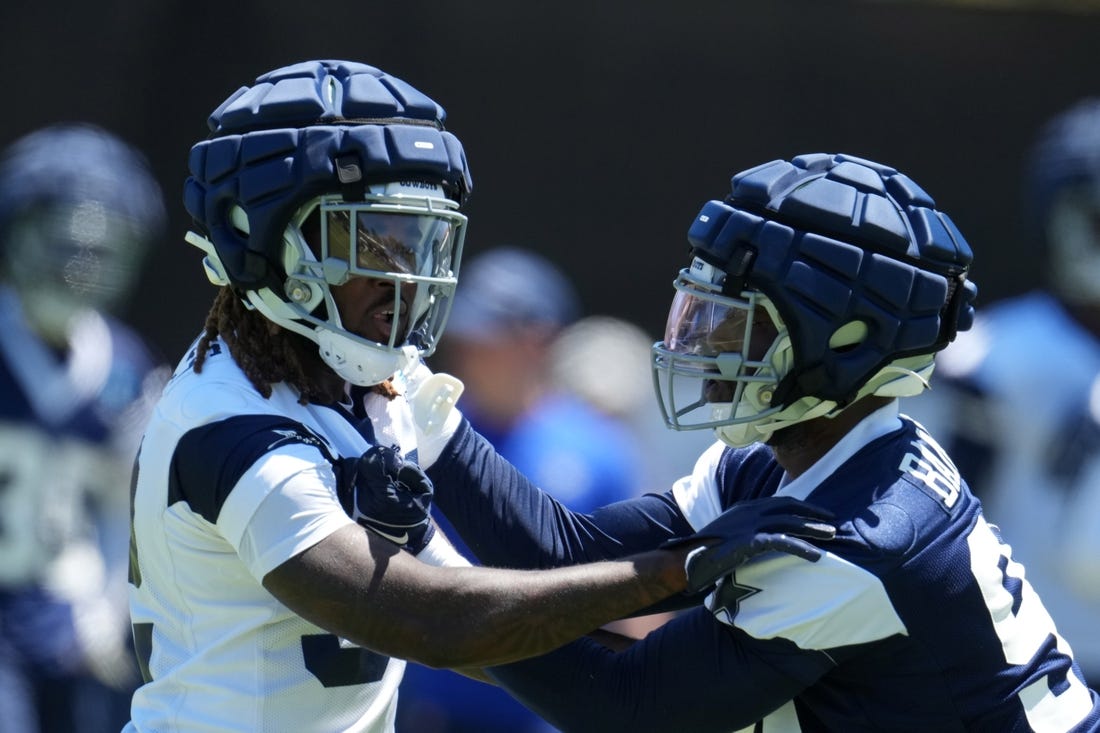 Jul 27, 2023; Oxnard, CA, USA; Dallas Cowboys running back Ronald Jones (left) and defensive end Ben Banogu wear Guardian helmet caps during training camp at Marriott Residence Inn-River Ridge Playing Fields. Mandatory Credit: Kirby Lee-USA TODAY Sports