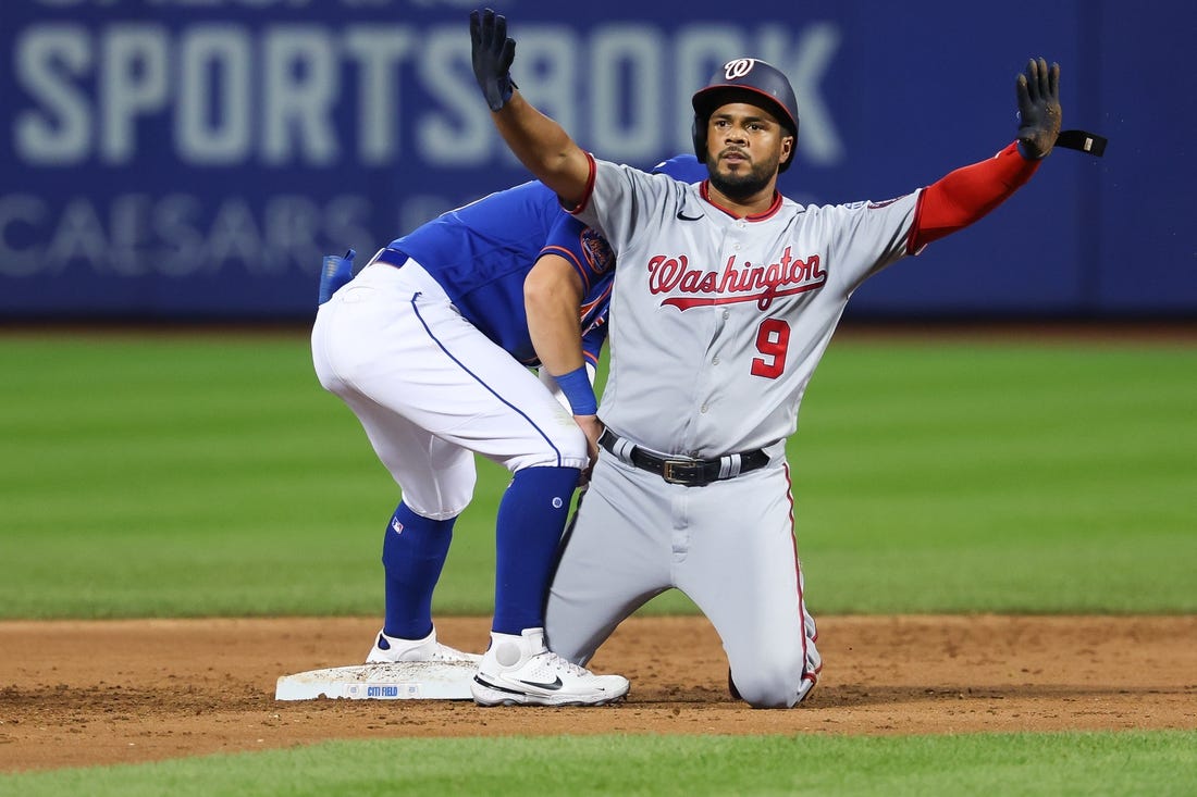 Jul 29, 2023; New York City, New York, USA; Washington Nationals third baseman Jeimer Candelario (9) reacts after an RBI double during the second inning as New York Mets shortstop Danny Mendick (15) holds the tag at Citi Field. Mandatory Credit: Vincent Carchietta-USA TODAY Sports