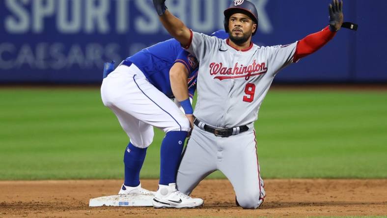 Jul 29, 2023; New York City, New York, USA; Washington Nationals third baseman Jeimer Candelario (9) reacts after an RBI double during the second inning as New York Mets shortstop Danny Mendick (15) holds the tag at Citi Field. Mandatory Credit: Vincent Carchietta-USA TODAY Sports