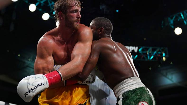 Jun 6, 2021; Miami, Florida, USA; Floyd Mayweather Jr. (Green Trunks) fights Logan Paul (Yellow Trunks) during an exhibition boxing match at Hard Rock Stadium. Mandatory Credit: Jasen Vinlove-USA TODAY Sports