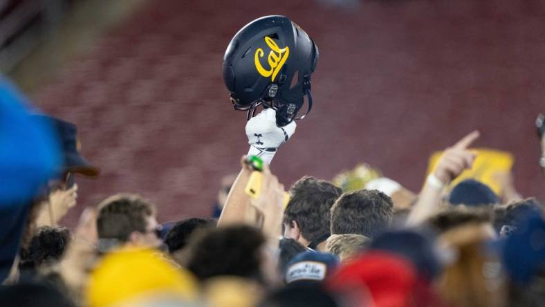 Nov 20, 2021; Stanford, California, USA; California Golden Bears helmet is raised into the air amongst fans after defeating the Stanford Cardinal at Stanford Stadium. Mandatory Credit: Stan Szeto-USA TODAY Sports