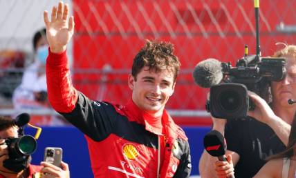 May 7, 2022; Miami Gardens, Florida, USA; Ferrari driver Charles Leclerc of Monaco waves to the fans in the stands after winning the pole position following qualifying for the Miami Grand Prix at Miami International Autodrome. Mandatory Credit: John David Mercer-USA TODAY Sports