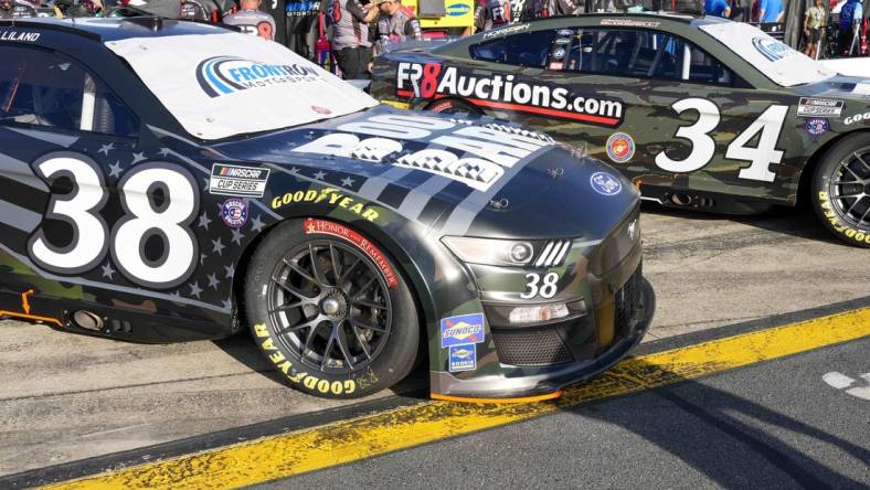 May 28, 2022; Concord, North Carolina, USA; The cars of NASCAR Cup Series driver Todd Gilliland (38) and driver Michael McDowell (34) sport military color schemes during Nascar Cup Practice at Charlotte Motor Speedway. Mandatory Credit: Jim Dedmon-USA TODAY Sports