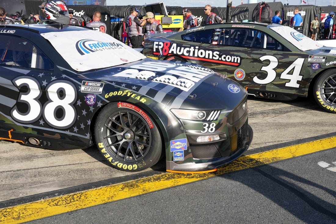 May 28, 2022; Concord, North Carolina, USA; The cars of NASCAR Cup Series driver Todd Gilliland (38) and driver Michael McDowell (34) sport military color schemes during Nascar Cup Practice at Charlotte Motor Speedway. Mandatory Credit: Jim Dedmon-USA TODAY Sports