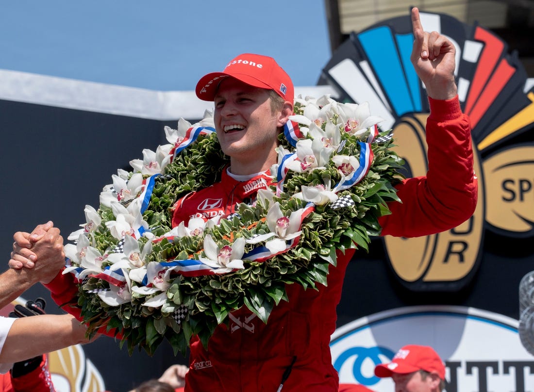 May 29, 2022; Indianapolis, IN, USA;  Chip Ganassi Racing driver Marcus Ericsson (8) celebrates on the podium with the milk after winning the 106th running of the Indianapolis 500 at Indianapolis Motor Speedway. Mandatory Credit: Mykal McEldowney-USA TODAY Sports