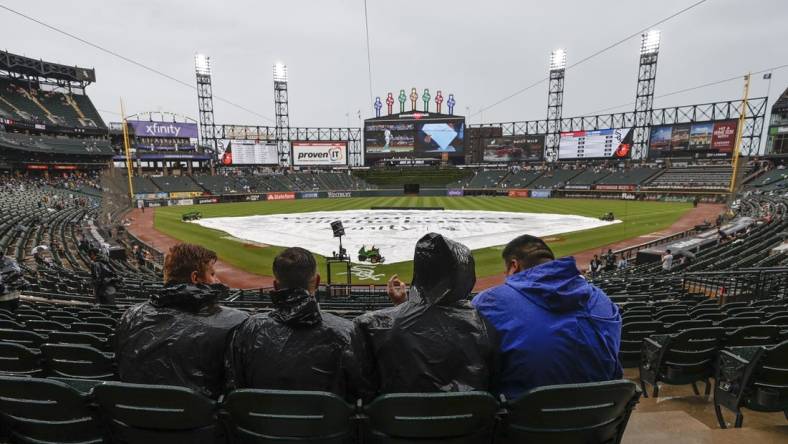 Jun 25, 2022; Chicago, Illinois, USA; Fans wait for a start of a baseball game between the Baltimore Orioles and the Chicago White Sox as tarp covers the infield during a rain delay at Guaranteed Rate Field. Mandatory Credit: Kamil Krzaczynski-USA TODAY Sports