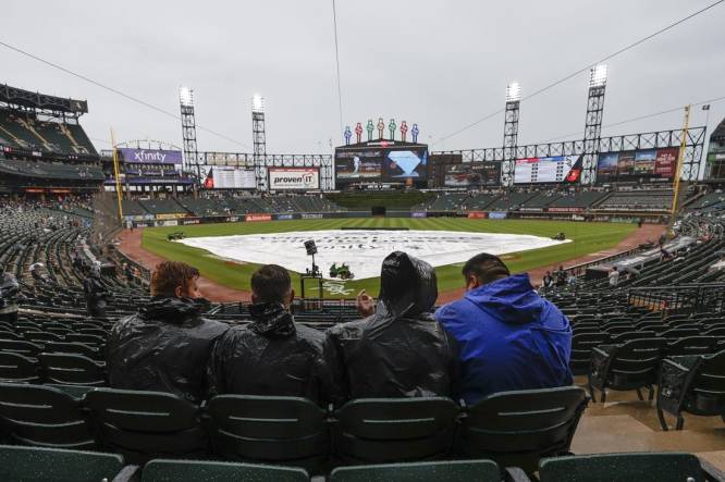Jun 25, 2022; Chicago, Illinois, USA; Fans wait for a start of a baseball game between the Baltimore Orioles and the Chicago White Sox as tarp covers the infield during a rain delay at Guaranteed Rate Field. Mandatory Credit: Kamil Krzaczynski-USA TODAY Sports