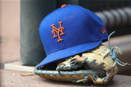 Jul 13, 2022; Atlanta, Georgia, USA; A detailed view of a New York Mets hat and glove in the dugout against the Atlanta Braves in the eighth inning at Truist Park. Mandatory Credit: Brett Davis-USA TODAY Sports