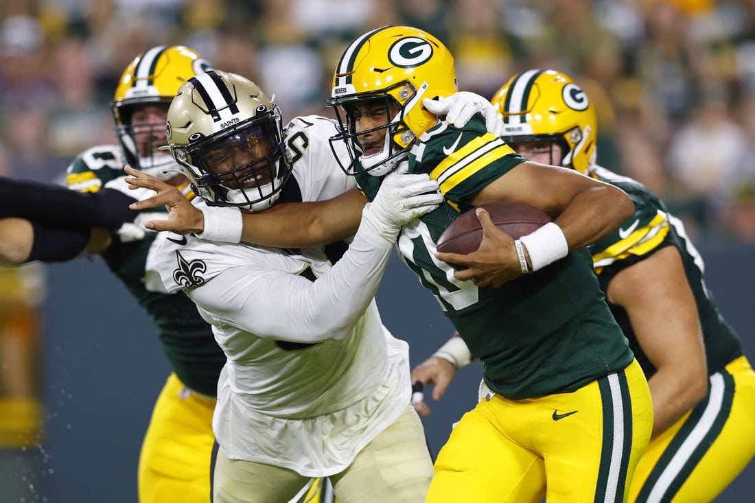 Aug 19, 2022; Green Bay, Wisconsin, USA;  Green Bay Packers quarterback Jordan Love (10) is tackled by New Orleans Saints defensive end Taco Charlton (54) during the second quarter at Lambeau Field. Mandatory Credit: Jeff Hanisch-USA TODAY Sports