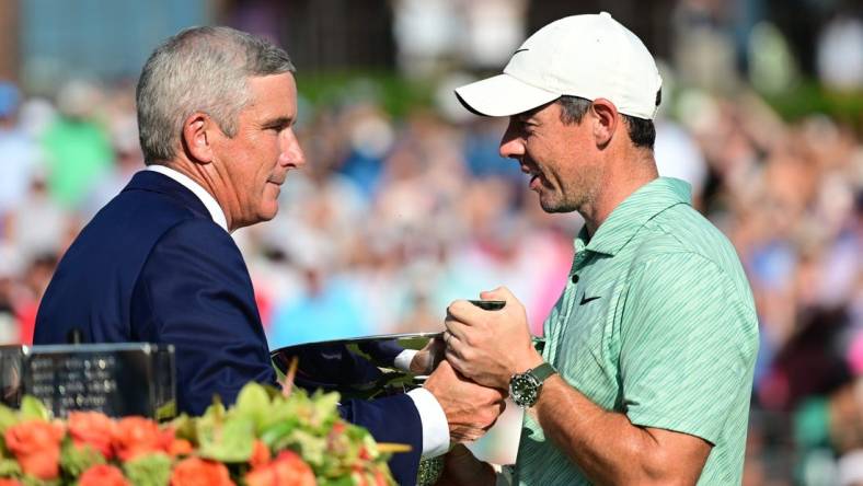 Aug 28, 2022; Atlanta, Georgia, USA; PGA commissioner Jay Monahan hands the FedEx Cup trophy to Rory McIlroy during the final round of the TOUR Championship golf tournament. Mandatory Credit: Adam Hagy-USA TODAY Sports