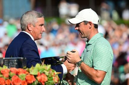 Aug 28, 2022; Atlanta, Georgia, USA; PGA commissioner Jay Monahan hands the FedEx Cup trophy to Rory McIlroy during the final round of the TOUR Championship golf tournament. Mandatory Credit: Adam Hagy-USA TODAY Sports