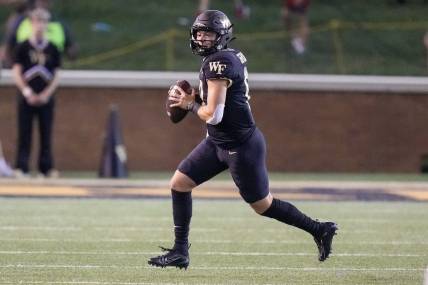 Sep 1, 2022; Winston-Salem, North Carolina, USA; Wake Forest Demon Deacons quarterback Mitch Griffis (12) scrambles out of the pocket to pass against the Virginia Military Institute Keydets during the first half at Truist Field. Mandatory Credit: Jim Dedmon-USA TODAY Sports