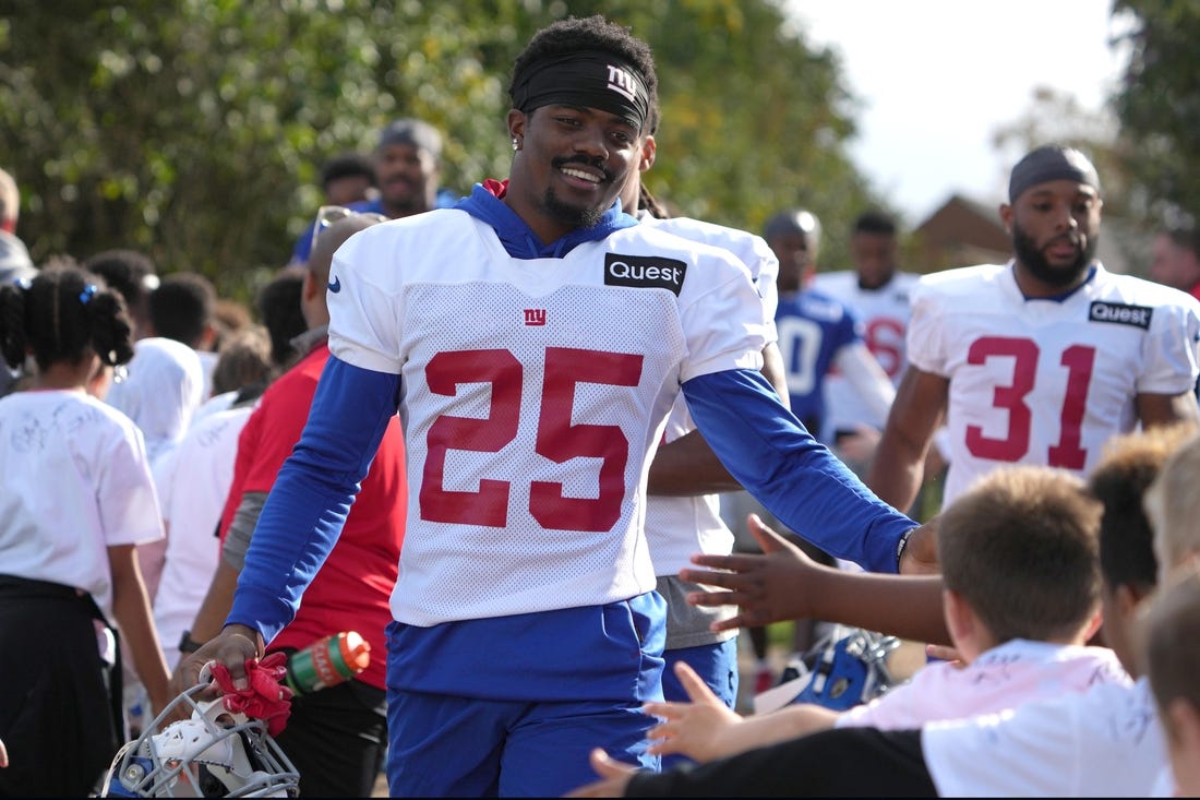 Oct 7,, 2022; Thundridge, United Kingdom; New York Giants cornerback Rodarius Williams (25) is greeted by children during practice at Hanbury Manor. Mandatory Credit: Kirby Lee-USA TODAY Sports