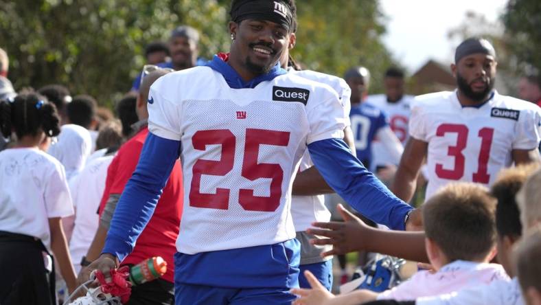 Oct 7,, 2022; Thundridge, United Kingdom; New York Giants cornerback Rodarius Williams (25) is greeted by children during practice at Hanbury Manor. Mandatory Credit: Kirby Lee-USA TODAY Sports