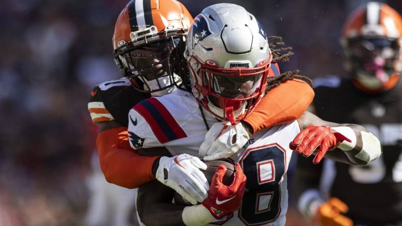 Oct 16, 2022; Cleveland, Ohio, USA; New England Patriots running back Rhamondre Stevenson (38) runs the ball as Cleveland Browns linebacker Jacob Phillips (50) tackles him from behind during the first quarter at FirstEnergy Stadium. Mandatory Credit: Scott Galvin-USA TODAY Sports