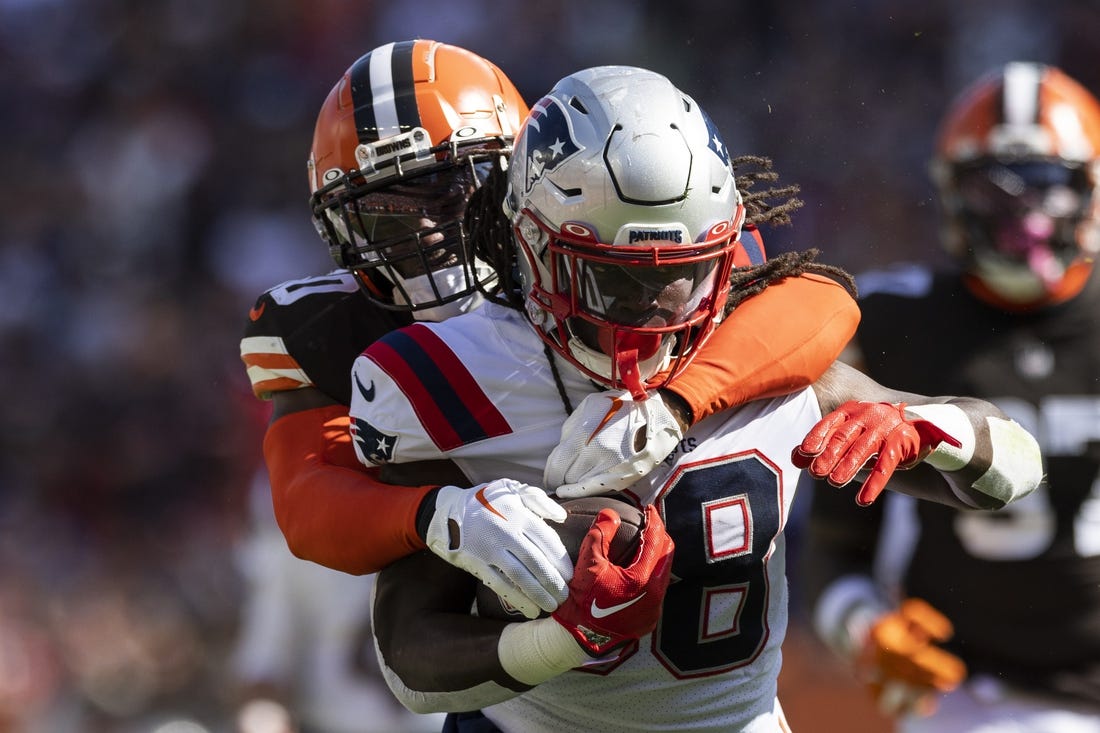 Oct 16, 2022; Cleveland, Ohio, USA; New England Patriots running back Rhamondre Stevenson (38) runs the ball as Cleveland Browns linebacker Jacob Phillips (50) tackles him from behind during the first quarter at FirstEnergy Stadium. Mandatory Credit: Scott Galvin-USA TODAY Sports