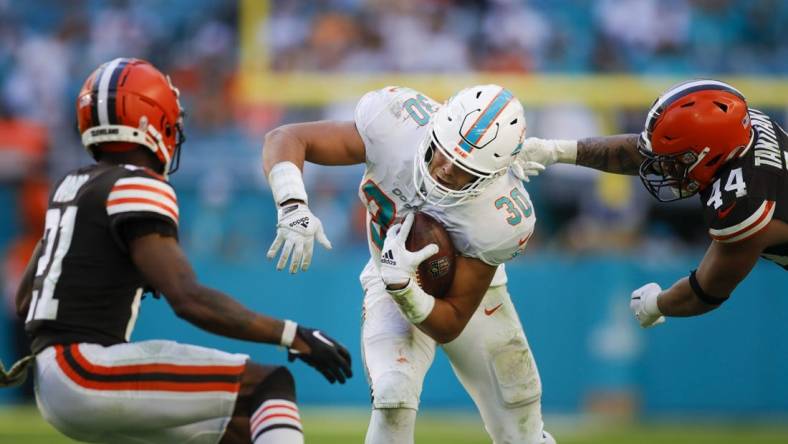 Nov 13, 2022; Miami Gardens, Florida, USA; Miami Dolphins fullback Alec Ingold (30) runs with the football ahead of Cleveland Browns linebacker Sione Takitaki (44) during the fourth quarter at Hard Rock Stadium. Mandatory Credit: Sam Navarro-USA TODAY Sports