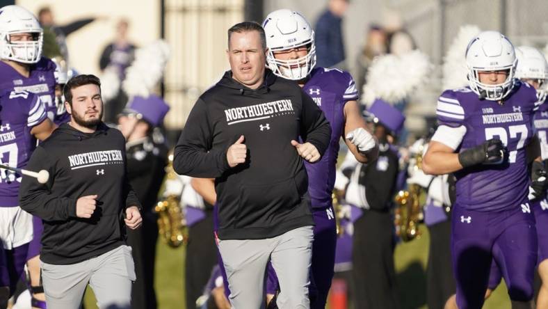 Nov 26, 2022; Evanston, Illinois, USA; Northwestern Wildcats head coach Pat Fitzgerald leads his team on the field against the Illinois Fighting Illini at Ryan Field. Mandatory Credit: David Banks-USA TODAY Sports