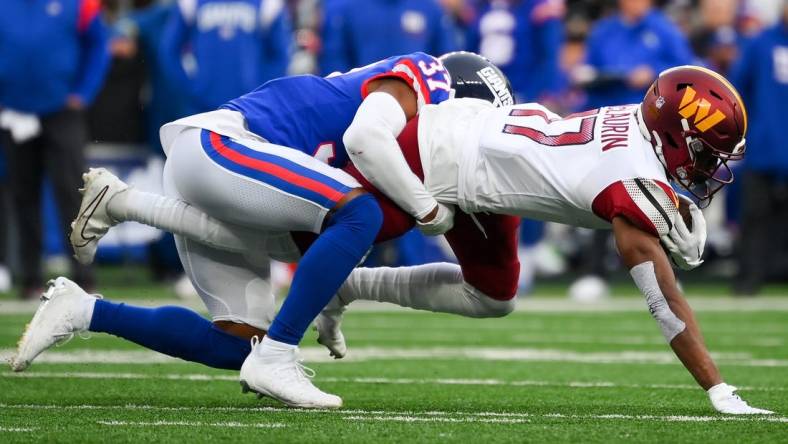 Dec 4, 2022; East Rutherford, New Jersey, USA; Washington Commanders wide receiver Terry McLaurin (17) dives for extra yards while being tackled by New York Giants cornerback Fabian Moreau (37) during the second half at MetLife Stadium. Mandatory Credit: Rich Barnes-USA TODAY Sports