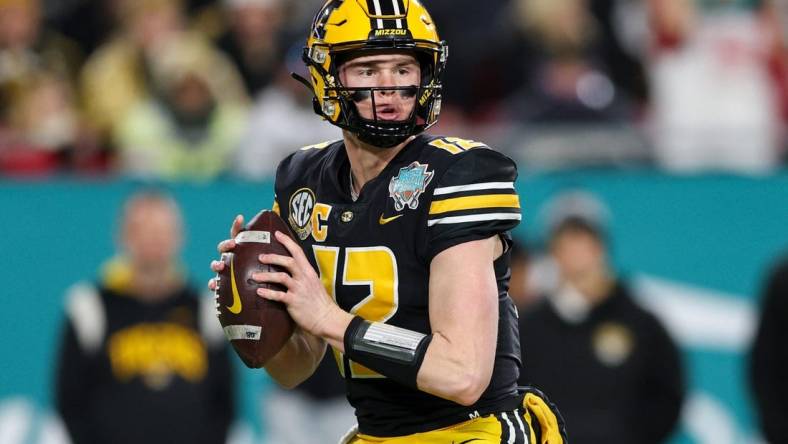 Dec 23, 2022; Tampa, Florida, USA; Missouri Tigers quarterback Brady Cook (12) drops back to pass against the Wake Forest Demon Deacons in the first quarter in the 2022 Gasparilla Bowl at Raymond James Stadium. Mandatory Credit: Nathan Ray Seebeck-USA TODAY Sports