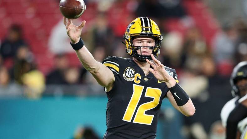 Dec 23, 2022; Tampa, Florida, USA; Missouri Tigers quarterback Brady Cook (12) throws a pass against the Wake Forest Demon Deacons during the first quarter in the 2022 Gasparilla Bowl at Raymond James Stadium. Mandatory Credit: Nathan Ray Seebeck-USA TODAY Sports