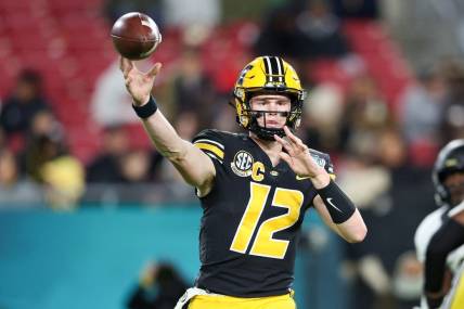 Dec 23, 2022; Tampa, Florida, USA; Missouri Tigers quarterback Brady Cook (12) throws a pass against the Wake Forest Demon Deacons during the first quarter in the 2022 Gasparilla Bowl at Raymond James Stadium. Mandatory Credit: Nathan Ray Seebeck-USA TODAY Sports