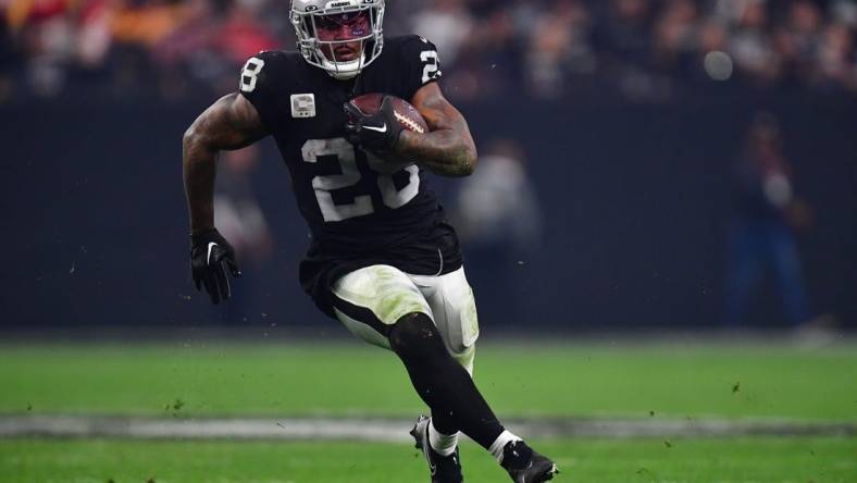 Jan 7, 2023; Paradise, Nevada, USA; Las Vegas Raiders running back Josh Jacobs (28) runs the ball against the Kansas City Chiefs during the second half at Allegiant Stadium. Mandatory Credit: Gary A. Vasquez-USA TODAY Sports