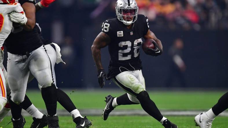 Jan 7, 2023; Paradise, Nevada, USA; Las Vegas Raiders running back Josh Jacobs (28) runs the ball against the Kansas City Chiefs during the second half at Allegiant Stadium. Mandatory Credit: Gary A. Vasquez-USA TODAY Sports