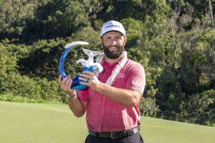 January 8, 2023; Maui, Hawaii, USA; Jon Rahm hoists the trophy on the 18th hole during the final round of the Sentry Tournament of Champions golf tournament at Kapalua Resort - The Plantation Course. Mandatory Credit: Kyle Terada-USA TODAY Sports