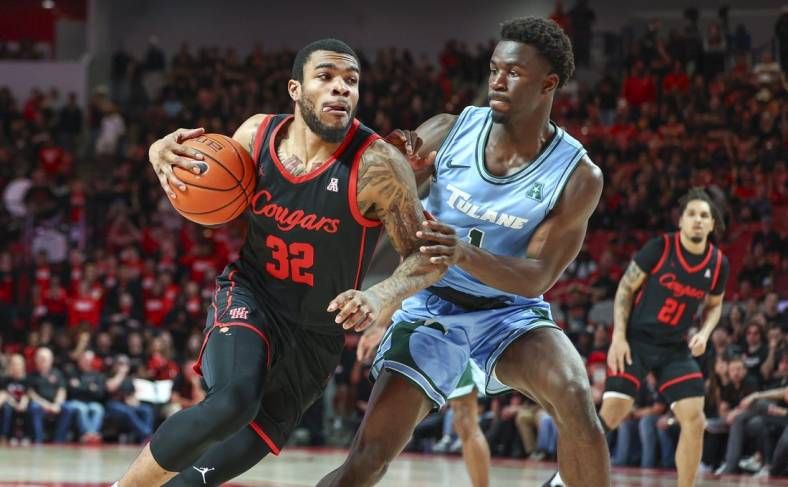Feb 22, 2023; Houston, Texas, USA; Houston Cougars forward Reggie Chaney (32) drives with the ball as Tulane Green Wave guard Sion James (1) defends during the second half at Fertitta Center. Mandatory Credit: Troy Taormina-USA TODAY Sports