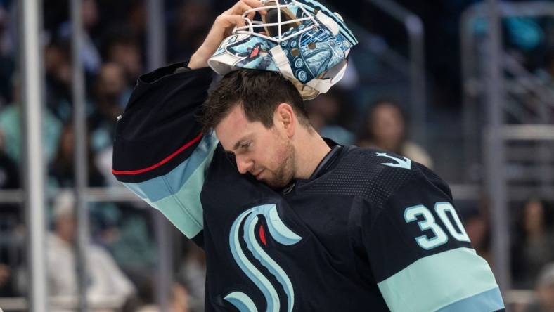 Apr 1, 2023; Seattle, Washington, USA; Seattle Kraken goalie Martin Jones (30) puts on his helmet during a game against the Los Angeles Kings at Climate Pledge Arena. Mandatory Credit: Stephen Brashear-USA TODAY Sports