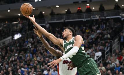Apr 26, 2023; Milwaukee, Wisconsin, USA; Milwaukee Bucks forward Giannis Antetokounmpo (34) lays up a shot against Miami Heat center Bam Adebayo (13) during game five of the 2023 NBA Playoffs at Fiserv Forum. Mandatory Credit: Michael McLoone-USA TODAY Sports
