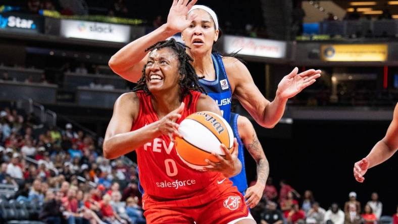 May 19, 2023; Indianapolis, Indiana, USA; Indiana Fever guard Kelsey Mitchell (0) shoots the ball while Connecticut Sun center Brionna Jones (42) defends in the second half at Gainbridge Fieldhouse. Mandatory Credit: Trevor Ruszkowski-USA TODAY Sports