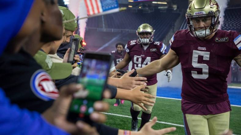 Fans greet Michigan Panthers Jamal Milan (94), Frank Ginda (5) and their teammates as they walk into the field before the start of their game against the Birmingham Stallions at Ford Field in Detroit on Saturday, May 20, 2023.