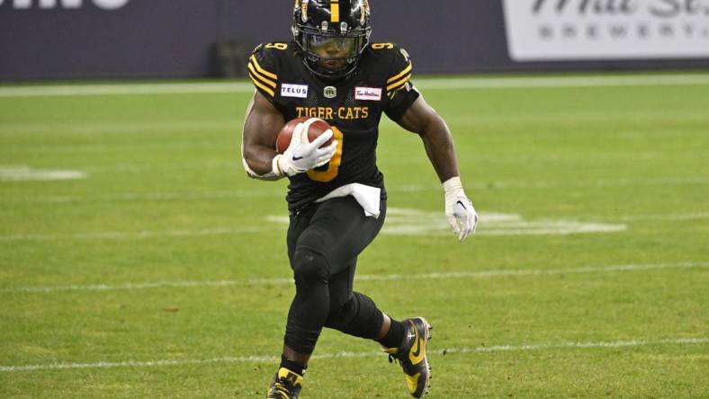 Jun 18, 2023; Toronto, Ontario, CAN;  Hamilton 
Tiger-Cats running back James Butler (9) runs with the ball against the Toronto Argonauts in the fourth quarter at BMO Field. Mandatory Credit: Dan Hamilton-USA TODAY Sports