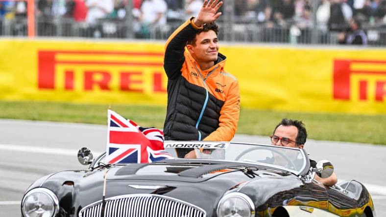 Jun 18, 2023; Montreal, Quebec, CAN; McLaren driver Lando Norris (GBR) parades and salutes the crowd before the Canadian Grand Prix at Circuit Gilles Villeneuve. Mandatory Credit: David Kirouac-USA TODAY Sports