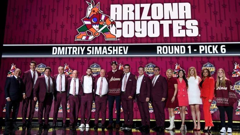 Jun 28, 2023; Nashville, Tennessee, USA; Arizona Coyotes draft pick Dmitriy Simashev stands with Coyotes staff after being selected with the sixth pick in round one of the 2023 NHL Draft at Bridgestone Arena. Mandatory Credit: Christopher Hanewinckel-USA TODAY Sports