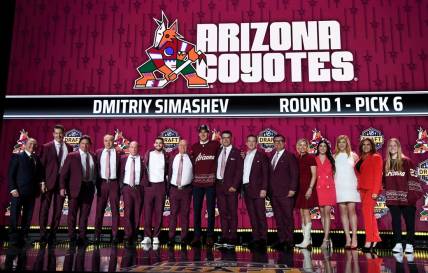 Jun 28, 2023; Nashville, Tennessee, USA; Arizona Coyotes draft pick Dmitriy Simashev stands with Coyotes staff after being selected with the sixth pick in round one of the 2023 NHL Draft at Bridgestone Arena. Mandatory Credit: Christopher Hanewinckel-USA TODAY Sports