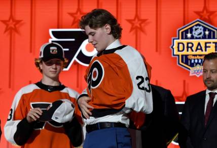 Jun 28, 2023; Nashville, Tennessee, USA; Philadelphia Flyers draft pick Oliver Bonk puts on his sweater after being selected with the twenty second pick in round one of the 2023 NHL Draft at Bridgestone Arena. Mandatory Credit: Christopher Hanewinckel-USA TODAY Sports