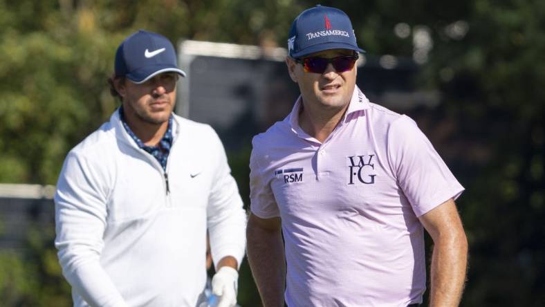 July 17, 2023; Hoylake, ENGLAND, GBR; Brooks Koepka (left) and Zach Johnson (right) watch a tee shot on the fifth hole during a practice round of The Open Championship golf tournament at Royal Liverpool. Mandatory Credit: Kyle Terada-USA TODAY Sports