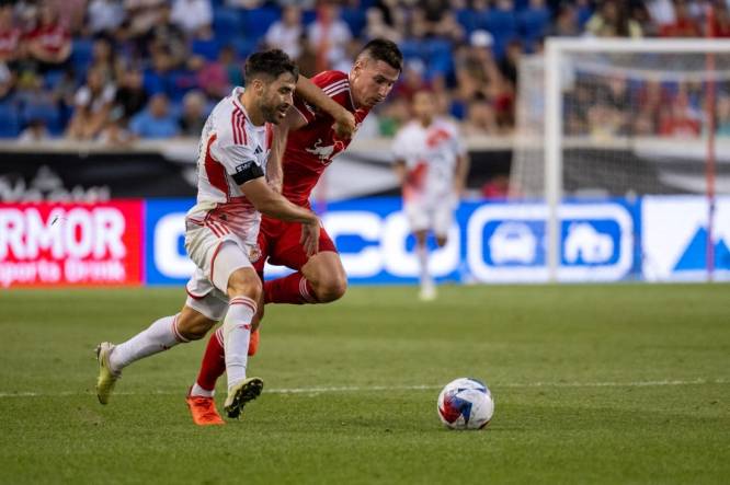 Jul 22, 2023; Harrison, NJ, USA; New England Revolution midfielder Carles Gil (10) fights for the ball against New York Red Bulls defender Sean Nealis (15) during the first half at Red Bull Arena. Mandatory Credit: Mark Smith-USA TODAY Sports