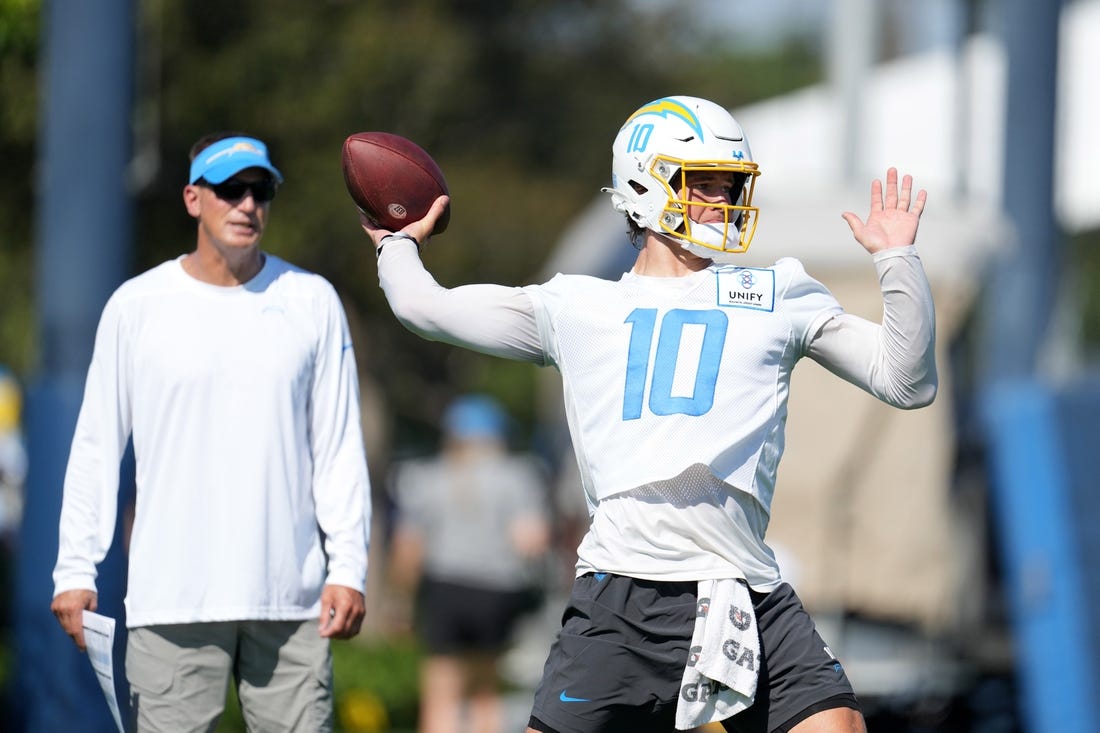 Jul 26, 2023; Costa Mesa, CA, USA; Los Angeles Chargers quarterback Justin Herbert (10) throws the ball as quarterbacks coach Doug Nussmeier watches during training camp at Jack Hammett Sports Complex. Mandatory Credit: Kirby Lee-USA TODAY Sports