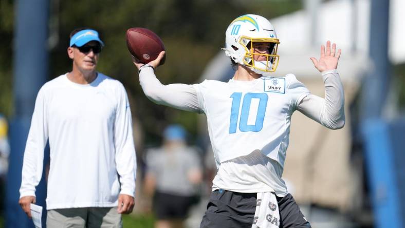 Jul 26, 2023; Costa Mesa, CA, USA; Los Angeles Chargers quarterback Justin Herbert (10) throws the ball as quarterbacks coach Doug Nussmeier watches during training camp at Jack Hammett Sports Complex. Mandatory Credit: Kirby Lee-USA TODAY Sports