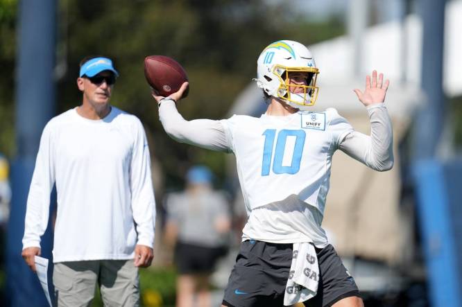 Jul 26, 2023; Costa Mesa, CA, USA; Los Angeles Chargers quarterback Justin Herbert (10) throws the ball as quarterbacks coach Doug Nussmeier watches during training camp at Jack Hammett Sports Complex. Mandatory Credit: Kirby Lee-USA TODAY Sports