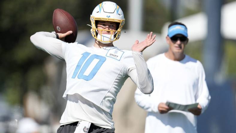 Jul 26, 2023; Costa Mesa, CA, USA; Los Angeles Chargers quarterback Justin Herbert (10) throws the ball as quarterbacks coach Doug Nussmeier watches during training camp at Jack Hammett Sports Complex. Mandatory Credit: Kirby Lee-USA TODAY Sports