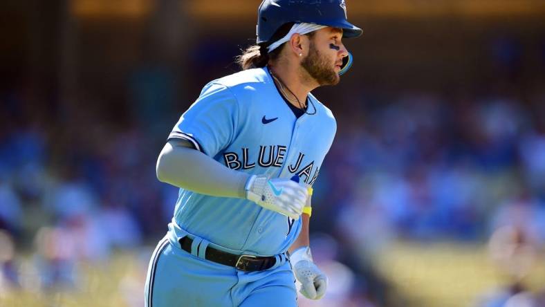 Jul 26, 2023; Los Angeles, California, USA; Toronto Blue Jays shortstop Bo Bichette (11) runs after hitting a two run RBI single against the Los Angeles Dodgers during the eighth inning at Dodger Stadium. Mandatory Credit: Gary A. Vasquez-USA TODAY Sports