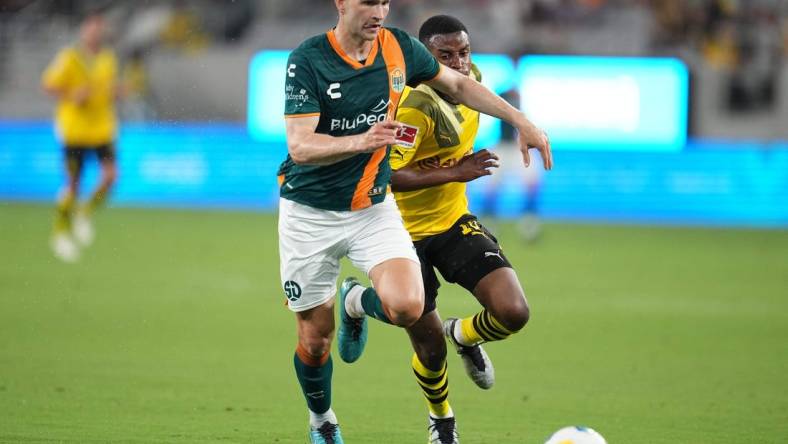 Jul 27, 2023; San Diego, California, USA;  San Diego Loyal defender Grant Stoneman (5) battles for the ball against Borussia Dortmund forward Youssoufa Moukoko (18) during the first half at Snapdragon Stadium. Mandatory Credit: Ray Acevedo-USA TODAY Sports