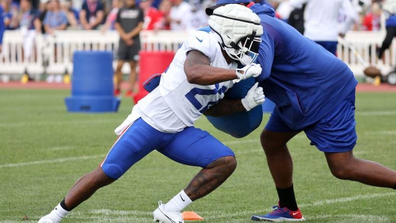 Bills Damien Harris fight off a block during training camp.