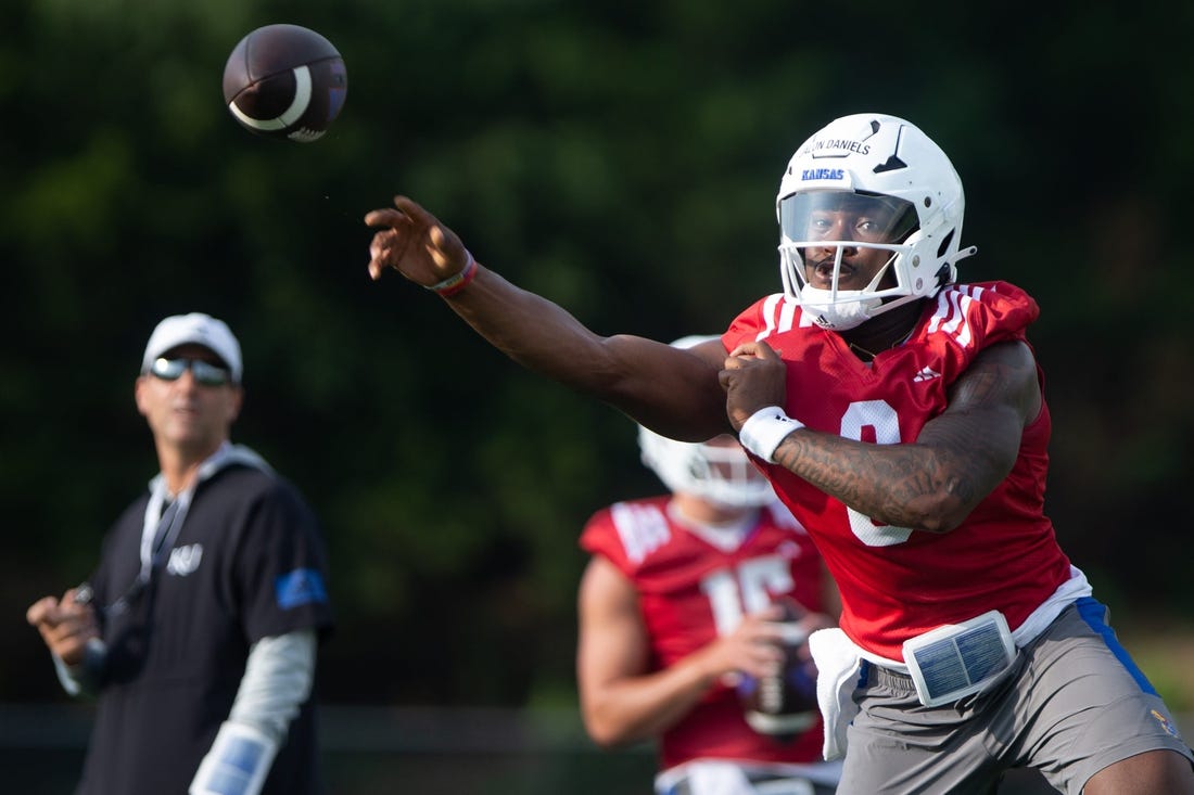 Kansas junior quarterback Jalon Daniels (6) practices passes during Tuesday's outdoor practice.